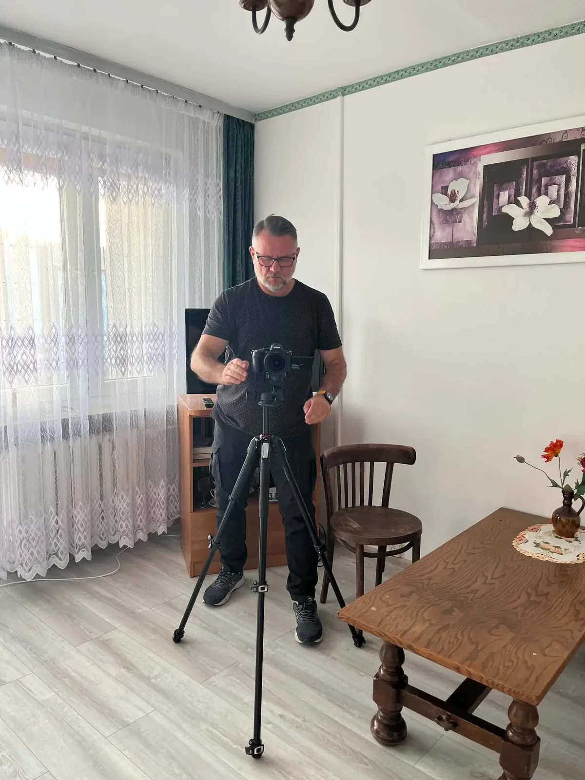 Grzegorz Niedźwiedź przygotowuje zdjęcia wnętrza aparatem na statywie